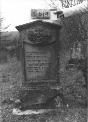 Grabstein 154 (Index: 99608838) Material: Sandstein Zustand: gut Maße HxBxT: 177x57x25 cm Beschreibung: Stele, profilierter Sockel, Giebel, Schriftfeld eingetieft mit Konvexbogenabschluß Symbolik: Blüten: Grabstein 154