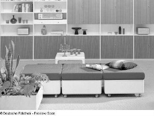 Beistelltisch : Möbelprogramm "variopur" (1973; VEB Petrolchemisches Kombinat Schwedt). Drei Hocker mit Beistelltisch und Blumenkasten vor Anbauwand