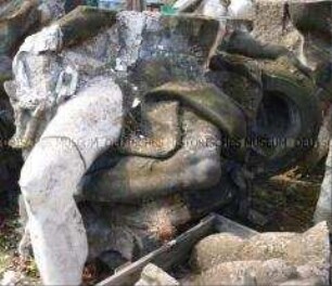 Fragment einer Zeughaus-Bauplastik: Gekreuzte Beine und Hand mit Kanonenrohr eines aus der ........-Gruppe (Dachbalustrade, .....seite) ???
