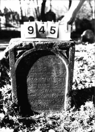 Grabstein 945 (Index: 99753156) Material: Sandstein Zustand: leicht verwittert Maße HxBxT: 65x46x23 cm Beschreibung: Stele, gerader Abschluß, Schriftfeld eingetieft mit Rundbogenabschluß: Grabstein 945