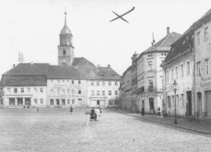 Bischofswerda. Altmarkt mit Wohnhäusern mit Läden. Blick nach Nordost zum Turm der Christuskirche