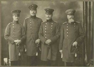 Vier Offiziere vom Stab der 26. Infanterie-Division: die Majore Stühmke, Brüggemann, Intendanturrat Klaus, Generaloberarzt Dr. Dannecker, stehend, in Uniform, Mütze, Brustbilder