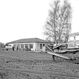 Sporteinrichtungen: Sportanlage am Kortenkamp: Ausbau: Hauptspielfeld: Aufbringen von Kies: rechts Planierraupe: links hinten Arbeiter: dahinter Sportlerheim: rechts Baum