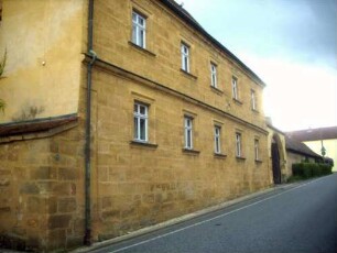 Ansicht von Nordosten mit Pfarrhof (erbaut Jahr 1625 auf der Kirchhofmauer) über Traufseite
