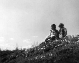 Kinderbilder. Zwei Kinder, auf einem Wiesenhügel sitzend