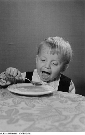 Ein Kind beim Verzehr von Nudelsuppe