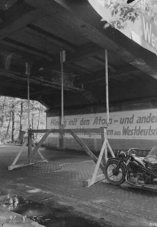 Eisenbahnbrücke der Grubenbahn zum Industrie-Kraftwerk Lauta über eine Dorfstraße. Untersicht auf Holzgerüst mit Meßstellen für das (Durchbiegungs-?)Verhalten des Brückenüberbaues; am Widerlager Losung "Hinweg mit den Atom- und Massenvernichtungswaffen aus Westdeutschland" : Laubusch (Niederlausitz). Eisenbahnbrücke der Grubenbahn zum Industrie-Kraftwerk Lauta über eine Dorfstraße. Untersicht auf Holzgerüst mit Meßstellen für das (Durchbiegungs-?)Verhalten des Brückenüberbaues; am Widerlager Losung "Hinweg mit den Atom- und Massenvernichtungswaffen aus Westdeutschland"