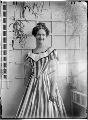 Wohnung der Familie Knochenhauer. Junge Dame (vermutlich Edith Stambke), vor einer Zimmerpflanzenwand stehend : Kattowitz, Friedensstraße 2. Wohnung der Familie Knochenhauer. Junge Dame (vermutlich Edith Stambke), vor einer Zimmerpflanzenwand stehend