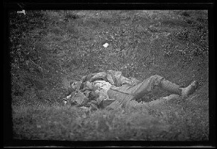 Nicht identifizierbare Gegend in Nordfrankreich oder Belgien: gefallener Soldat in einer Graskuhle (Blick von oben) ("Gefallene")