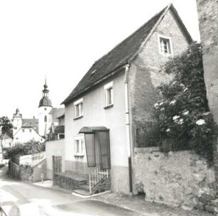 Colditz, Schloßgasse 11. Wohnhaus (18. Jh.). Straßenansicht mit Turm der Stadtkirche St. Egidien
