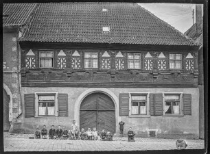 Schulhaus (vor dem Haus knien Buben)