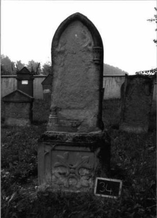 Grabstein 34 (Index: 99936941) Material: Sandstein Zustand: Stele abgeschiefert unter völligem Textverlust Maße HxBxT: 179x58x25 cm Beschreibung: ädikulaartige Stele mit Halbsäulen, profilierter Sockel, Spitzbogenabschluß Symbolik: Pflanzenornament im Sockel: Grabstein 34
