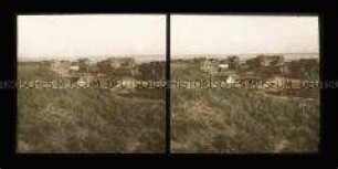 Blick über Dünen auf Wohnhäuser und Nordsee, Juist
