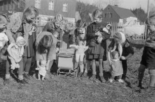 Kinder beim Spielen : Mädchen mit Puppenwagen und Spielzeugpuppen