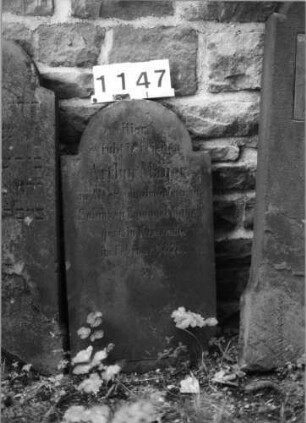 Grabstein 1147 (Index: 99630650) Material: Sandstein Zustand: verwittert Maße HxBxT: 80x43x9 cm Beschreibung: Stele mit eingezogenem Rundbogenabschluß: Grabstein 1147