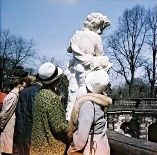 Dresden. Zwinger, zwei Besucherinnen betrachten die Skulptur eines Kindes, einen Delphin vor sich haltend