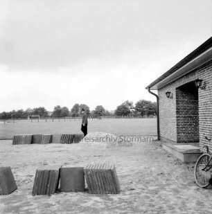 Sporteinrichtungen: Sportplatz: Neubau: rechts Umkleidehaus: im Vordergrund Stapel mit Gehwegplatten, dahinter Arbeiter