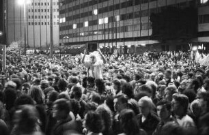 DDR-Demo. Eine Frau zeigt das Foto eines Inhaftierten