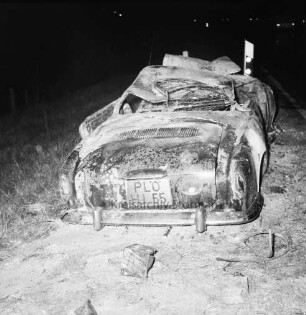 B 404: bei Herrenhaus Nütschau: Verkehrsunfall: Zusammenstoß von zwei Pkws und Auffahrunfall: am Straßenrand ausgebrannter Unfallwagen VW Karmann-Ghia nach Löschen, Leitpfosten: im Dunkeln, 1. Mai 1967