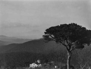 Landschaft : Blick über eine hügelige Landschaft mit einem Gebäude, vermutlich einer Kapelle