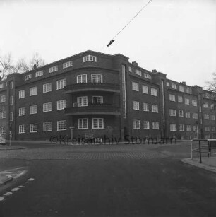 Mewesstraße / Kurze Straße [später Käthe-Kollwitz-Straße]: Wohnblock der Gemeinnützigen Wohnstättengenossenschaft eG Bad Oldesloe: davor Verkehrsschilder: links Einmündung der Ratzeburger Straße, rechts der Bahnhofstraße und vorn: rechts Geländer