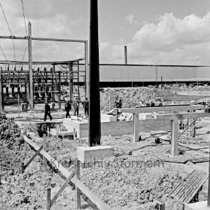 Gewerbegebiet Nord: Schleswag: Netzleitstelle: Betriebsgebäude in Bau: Arbeiter, Fundamente, Stahlträger: dahinter Umspannwerk: Stromleitungen, Freiluftschaltanlagen, Isolatoren, Transformatoren: im Hintergrund Tiefdruckerei des Axel-Springer-Verlags