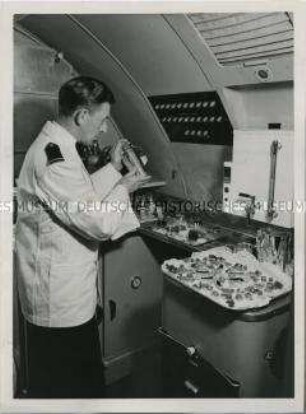 Flugbegleiter der British Overseas Airways Corporation bei der Getränke- und Imbisszubereitung