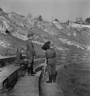 Drei Fotografen mit Kamera im Amphitheater von Saintes, von links nach rechts: Franz Prinz zu Sayn-Wittgenstein (sitzend), Hans-Adalbert von Stockhausen (stehend), Carl Albiker (?) (Aufnahme im Rahmen der Fotokampagne im besetzten Frankreich)
