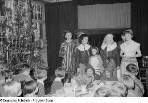 Kinder und kostümierte Teilnehmer der Weihnachtsfeier des VEB Offizin "Andersen Nexö"