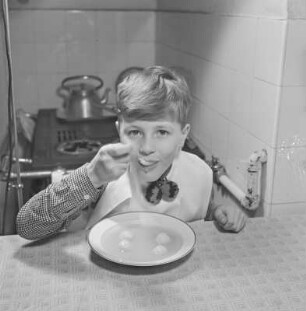 Junge isst Suppe mit Klößchen
