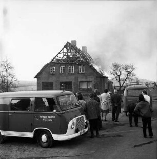Brand: Reetdachhaus auf Nachbarhof Holm: Funkenflug vom Brand des Hofes von Walter Ellerbrock: brennendes Dach: im Vordergrund Löschwagen der Feuerwehr und Zuschauer