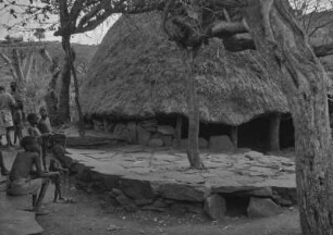 Dorf der Sidamo : Personen nahe einer Rundhütte in einem Dorf der Sidama.