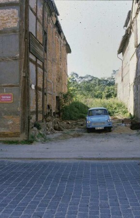 DDR. Neubrandenburg. Parkender Trabant in Baulücke neben dem Apostelamt Jesu Christi (wahrscheinlich Buttelstraße 14)