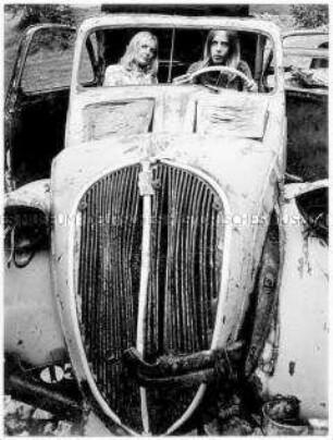 Zwei junge Frauen sitzen in einem alten Auto (Altersgruppe 18-21)