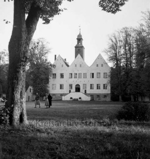 Herrenhaus: Jugendheim: Nordfront mit Außentreppe: davor Rasenfläche: links darauf zwei Frauen und ein Mädchen: vorn rechts und links Bäume