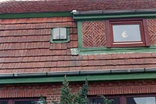 Lütjenseer Straße 8: traufständiges Backsteinhaus mit Mansarddach: Straßenfront, Detailaufnahme: in Mansardgeschoss Schleppgaube mit Backsteinzier
