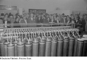 Besucher bei der Vorführung einer Textilmaschine auf der Technischen Messe 1953