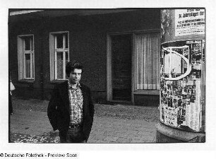 Der Fotograf Christian Borchert neben einer Litfaßsäule