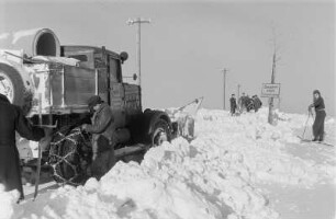 Reportage "Was kostet der Schnee?". Schneepflug im Einsatz. Ansicht mit Skiläufern