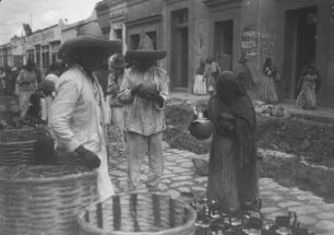 Auf dem Markt von Oaxaca de Juárez : Blick in eine Straße in Oaxaca de Juárez mit einem Händler, der Körbe und Töpfe anbietet