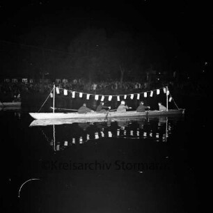 Karpfenfest: Neuhöfer Teich: Nachtaufnahme: Lampionkorso der Reinfelder Rudergemeinschaft: Vierer-Ruderboot, mit Lampionkette geschmückt: im Hintergrund Zuschauer am Ufer, 10. Oktober 1965