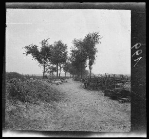 [bei Roclincourt (Dep. Pas-de-Calais, Frankreich):] Landstraße am Schützengraben "Dittelberger-Graben" (?) mit Stacheldrahthindernissen und Fässern