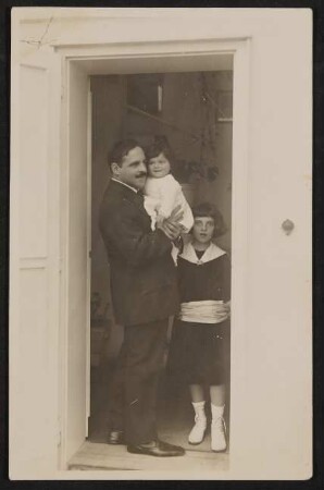 Jakob Wassermann steht im Türrahmen mit seinen Töchtern Judith und Eva