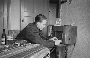 Zweiter Weltkrieg. Niederlande unter deutscher Besatzung. Angehöriger der deutschen Wehrmacht in der Unterkunft am Radio (wohl bei Den Haag)