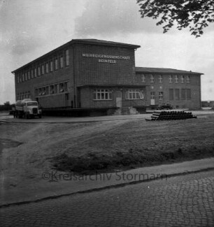 Meiereigenossenschaft Reinfeld: Hamburger Straße: Außenansicht: mit Firmenname an Fassade: Michlieferfahrzeug: im Vordergrund unbefestigtes Vorgelände, Straße