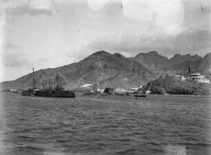 Sicht auf Aden : Blick vom Meer auf den Hafen der Stadt Aden und Teile des Vulkankraters. Im Vordergrund einige Schiffe. Rechts im Hintergrund der Big Ben Aden.