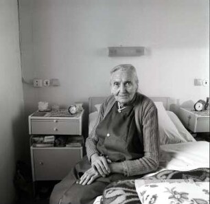Pflegeheim : Colditz. Portrait einer Seniorin eines Pflegeheims in ihrem Zimmer auf ihrem Bett