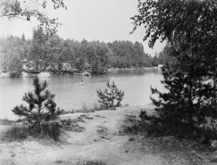Waldsee Biehain : Waldsee Biehain. Blick über den See mit Paddlerin zu Waldstück mit Bungalows