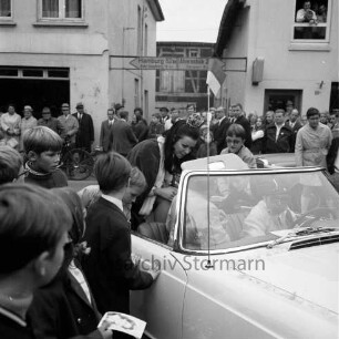 Karpfenfest: Umzug: "Miß Germany" Gesine Froese stehend im offenen Cabriolet: Kinder als Autogrammjäger: hinten Zuschauer, links Ladengeschäft "Carl Käselau", Wegweiser nach Hamburg und nach Ahrensbök, 12. Oktober 1969
