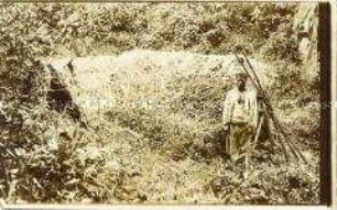 Afrikanischer Mann vor einer Hütte an der "Mannsquelle" am Kamerunberg